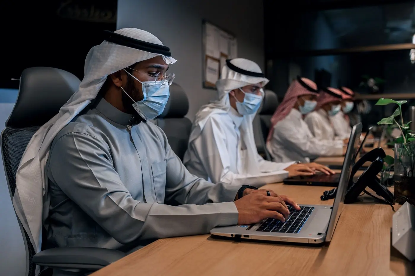 أعضاء من الفريق يراجعون العمل على أجهزتهم في المكتب